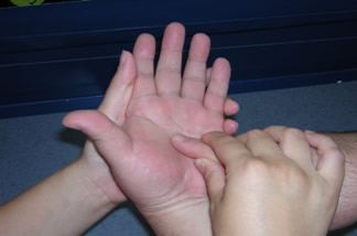 盲ろう者の手の平に、もう片方の盲ろう者の指で文字を書きます。